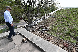 Sam Palmer, director of facilities and sustainability at Fayetteville Public Library, shows damage Monday, April 15, 2024, atop a portion of the library's roof after a fire Sunday night damaged the library building necessitating its closure Monday. Visit nwaonline.com/photo for today's photo gallery..(NWA Democrat-Gazette/Andy Shupe)